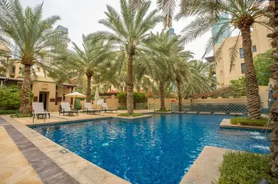 a swimming pool with palm trees in a resort at Bnbeyond Ultra-Luxe 2BR with Burj Khalifa Panorama in Dubai