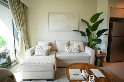 a living room with a white couch and a table at Burj Khalifa Light Show from your Bed in Dubai