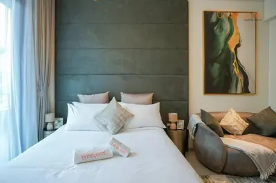 a bedroom with a large white bed and a couch at Signature Stay at The Autograph in Dubai