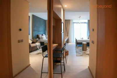 a living room with a couch and a table and chairs at Signature Stay at The Autograph in Dubai