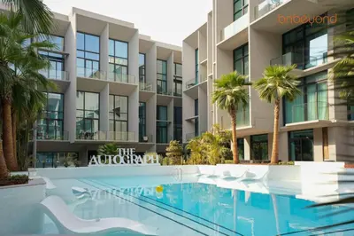 a swimming pool in front of a building with palm trees at Signature Stay at The Autograph in Dubai