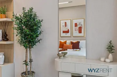 a mirror in a bedroom with a bed in it at Boho Grecian Studio in JVC Pool & Gym Access in Dubai
