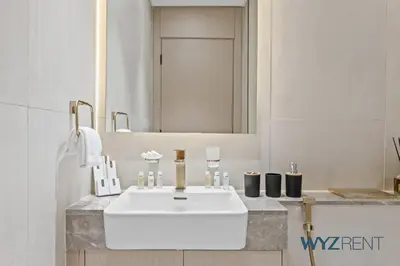 a bathroom with a white sink and a mirror at Boho Grecian Studio in JVC Pool & Gym Access in Dubai