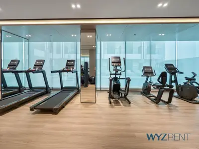 a gym with several treadmills and a mirror at Boho Grecian Studio in JVC Pool & Gym Access in Dubai
