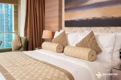 a hotel room with a white bed with pillows at Dubai Mall Apartments by Suitestay in Dubai
