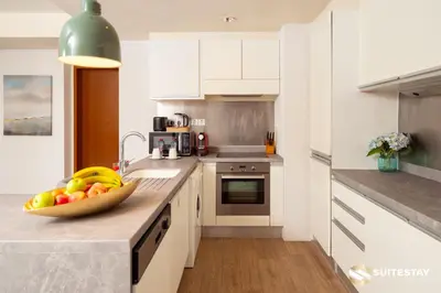 a kitchen with a bowl of fruit on a counter at Dubai Mall Apartments by Suitestay in Dubai