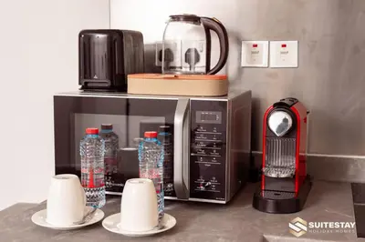 a counter with a coffee maker and bottles of water at Dubai Mall Apartments by Suitestay in Dubai