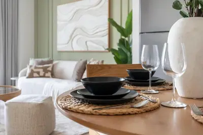 a dining room table with two plates and wine glasses at GuestReady - 1Bed l Lagoon Escape l Creek Beach in Dubai