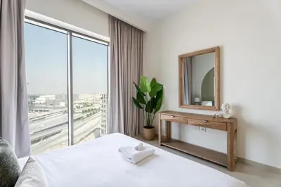 a bedroom with a bed and a mirror and a window at GuestReady - 1Bed l Lagoon Escape l Creek Beach in Dubai