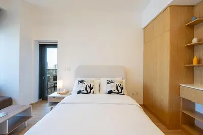 a bedroom with a large bed with a wooden headboard at Luxury Studio JVC Open View in Dubai