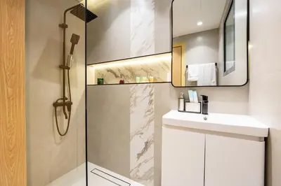 a bathroom with a shower and a sink and a mirror at Luxury Studio JVC Open View in Dubai