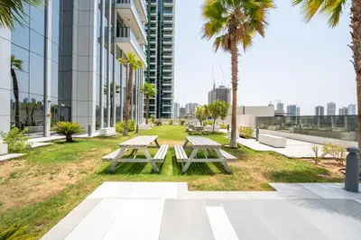 a park with picnic tables and palm trees in a building at Luxury Studio JVC Open View in Dubai