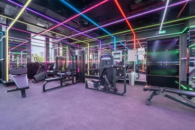 a gym with cardio equipment and neon lights at Luxury Studio JVC Open View in Dubai