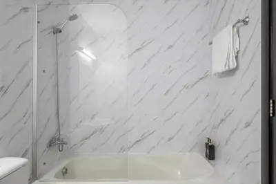 a white bathroom with a shower and a sink at 1 Bhk Huge Apartment In Heart of Dubai Marina in Dubai