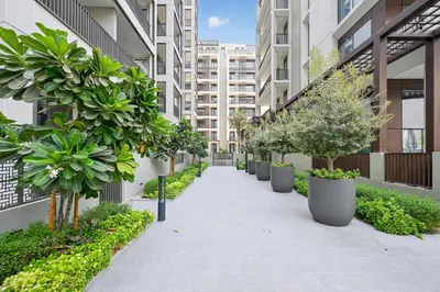 an internal courtyard of an apartment building with potted trees at Modern 3BD with Maid's Room near Lagoon at Lotus 4 in Dubai