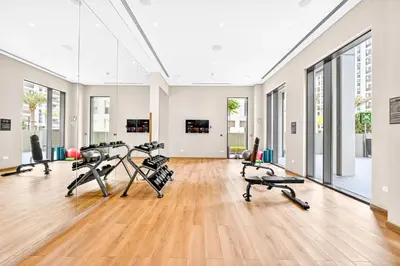 a gym with treadmills and elliptical machines at Modern 3BD with Maid's Room near Lagoon at Lotus 4 in Dubai