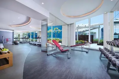 a gym with red chairs and large windows at Studio with Burj Khalifa view in Dubai