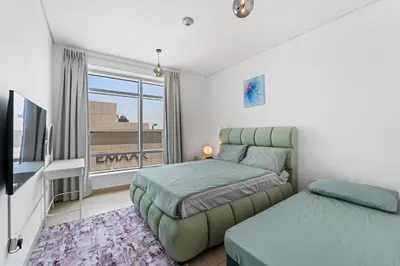 a bedroom with two beds and a tv and a window at Lux Retreat with Iconic Burj Khalifa Views in Dubai