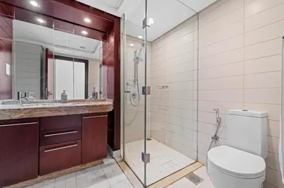 a bathroom with a toilet and a glass shower at Lux Retreat with Iconic Burj Khalifa Views in Dubai