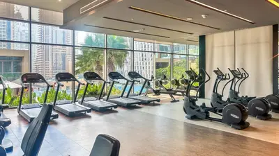 a gym with a row of treadmills and ellipticals at Exclusive 1BR in Marina Gate Dubai Marina - 46AB03 in Dubai