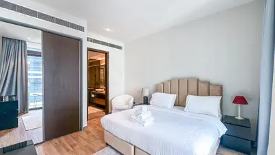 a bedroom with a large white bed and a desk at Exclusive 1BR in Marina Gate Dubai Marina - 46AB03 in Dubai