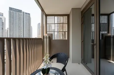 a balcony with a table and chairs and some buildings at GuestReady - Blue Bliss l 2Bed l Lagoon Escape in Dubai
