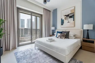 a bedroom with a large bed and a large window at GuestReady - Blue Bliss l 2Bed l Lagoon Escape in Dubai