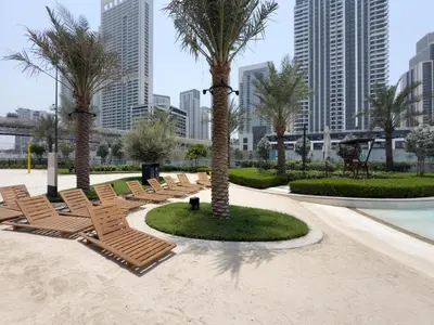 a group of chairs and palm trees in a park at GuestReady - Blue Bliss l 2Bed l Lagoon Escape in Dubai