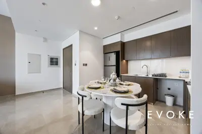 a kitchen and dining room with a table and chairs at Grande Residence Burj View 2 BR by Evoke Luxury in Dubai