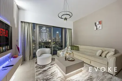 a living room with a couch and a table at Grande Residence Burj View 2 BR by Evoke Luxury in Dubai