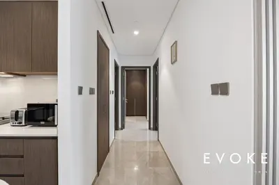 a kitchen with white walls and a hallway at Grande Residence Burj View 2 BR by Evoke Luxury in Dubai