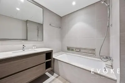 a bathroom with a tub and a sink and a shower at Grande Residence Burj View 2 BR by Evoke Luxury in Dubai
