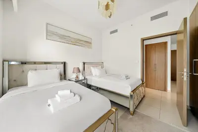 two beds in a room with white walls at Luxury 2BR with Burj Khalifa Views l Near Dubai Mall in Dubai