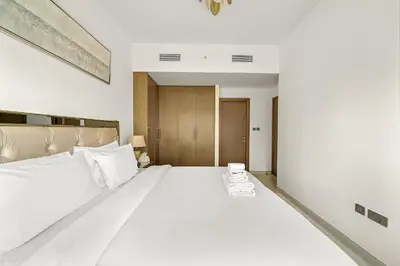a bedroom with a large white bed in a room at Luxury 2BR with Burj Khalifa Views l Near Dubai Mall in Dubai