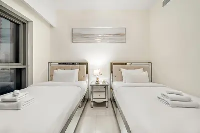 two twin beds in a room with a window at Luxury 2BR with Burj Khalifa Views l Near Dubai Mall in Dubai
