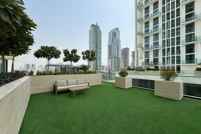 a balcony with a bench and green grass at Cozy Studio in JVC Dubai in Dubai
