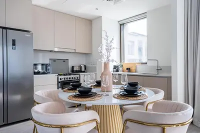 a kitchen with a table and chairs and a kitchen with a refrigerator at GuestReady - 2Bed l Lagoon Escape l Creek Beach in Dubai