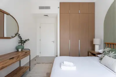 a bedroom with a bed and a mirror at GuestReady - 2Bed l Lagoon Escape l Creek Beach in Dubai