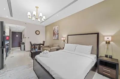 a bedroom with a large bed and a living room at Modern Studio at Elite Downtown Residence in Dubai