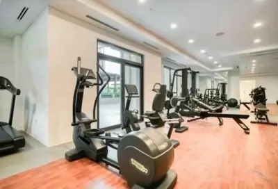 a gym with several tread machines in a room at Chic Apartment with Balcony & Views in Dubai