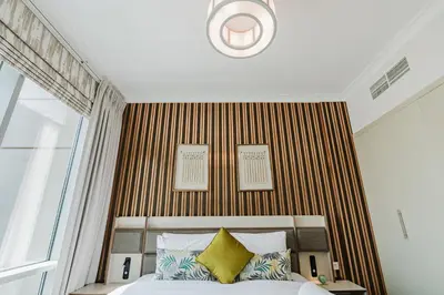 a bedroom with a large bed with yellow pillows at RH-Luxury 1BR Apt in Al Habtoor City with beautiful Canal View in Dubai