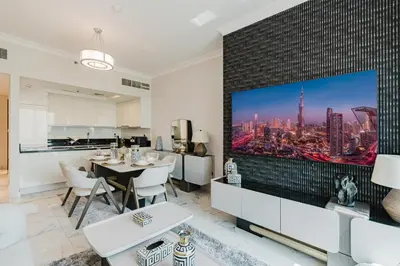 a kitchen and living room with a large tv on the wall at RH-Luxury 1BR Apt in Al Habtoor City with beautiful Canal View in Dubai