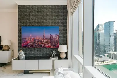 a living room with a tv on a wall at RH-Luxury 1BR Apt in Al Habtoor City with beautiful Canal View in Dubai