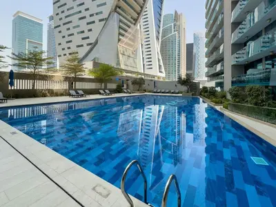 a large swimming pool in a city with tall buildings at DAYF-MER Stylish 1Bed in central location Business Bay in Dubai