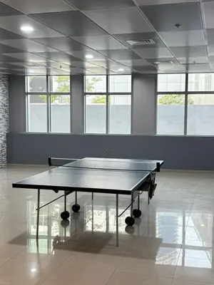 a ping pong table in a large room with windows at LYO guest house Dubai marina BEDSPACE in Dubai