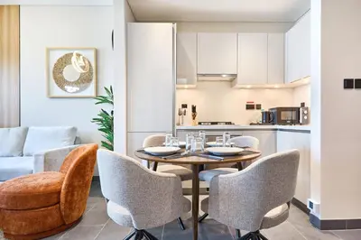 a dining room with a table and chairs and a kitchen at STAY BY LATINEM Luxury 1BR Plus Study Holiday Home CB 1013 Near Burj Khalifa in Dubai