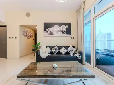 a living room with a couch and a glass table at Continental Tower Stylish 2BR and Private Hot Tub in Dubai
