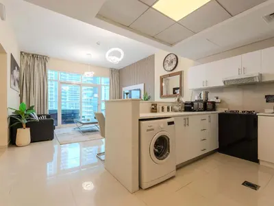a kitchen and living room with a washing machine at Continental Tower Stylish 2BR and Private Hot Tub in Dubai