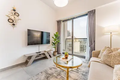 a living room with a couch and a tv at Near Circle Mall And Parks, Easy Access to Al Khail Road And Close to RTA Bus Stop, Lucky Residences, JVC by Deluxe Holiday Homes in Dubai