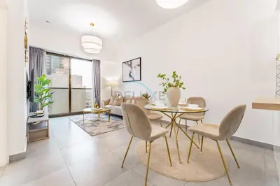 a living room with a dining room table and chairs at Near Circle Mall And Parks, Easy Access to Al Khail Road And Close to RTA Bus Stop, Lucky Residences, JVC by Deluxe Holiday Homes in Dubai